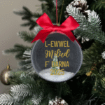 L ewwel milied f' darna 2025 round Christmas KS Creations bauble filled with snow and tree and gold font
